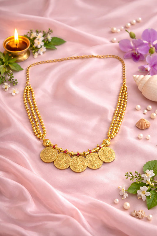 Five Lakshmi Coin Kasumala Necklace – traditional South Indian temple jewellery with Lakshmi coin pendants and multi-strand gold-tone bead chain on pink satin