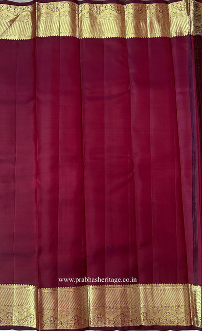 Matching wine-coloured blouse piece with a gold zari peacock border