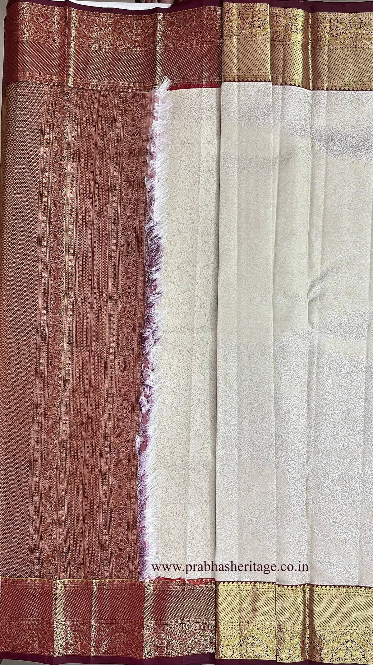 Korvai join where the ivory body meets the wine and gold zari border