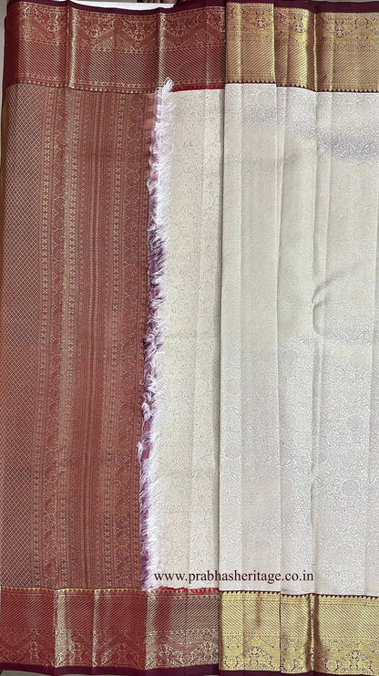 Korvai join where the ivory body meets the wine and gold zari border