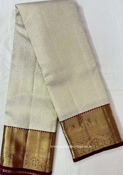Full length of the ivory Kanchipuram silk saree with its wine and gold Korvai border