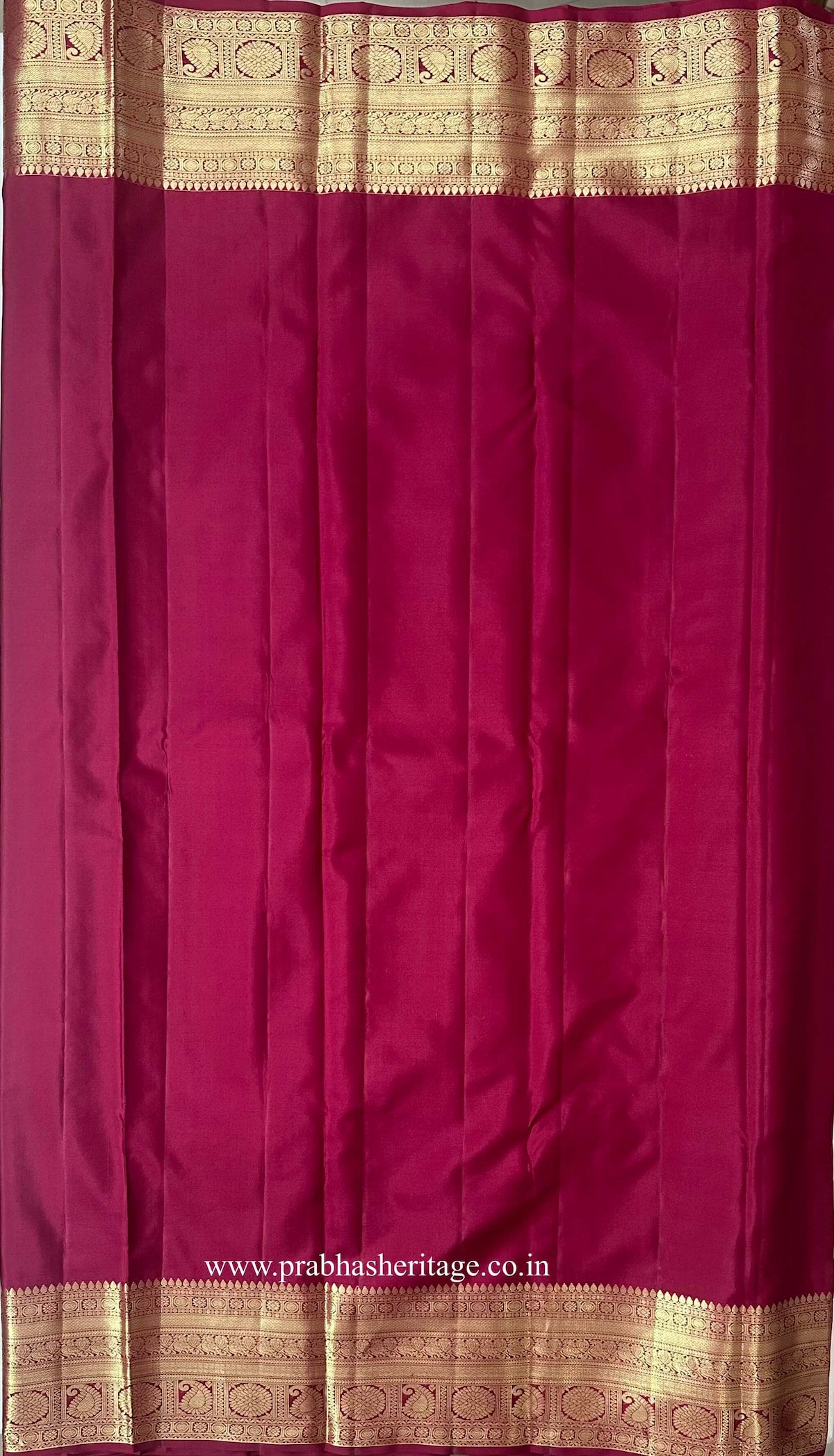 Plain deep magenta blouse piece with a broad gold zari paisley border