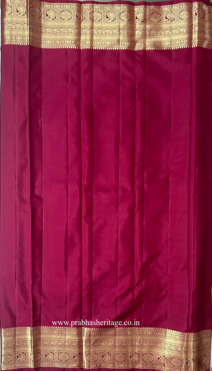 Plain deep magenta blouse piece with a broad gold zari paisley border