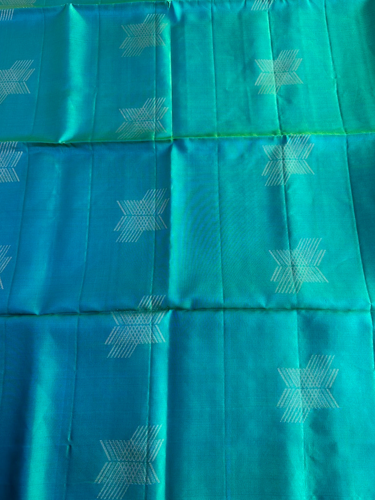 Delicate gold zari geometric motifs on the peacock aqua-turquoise silk body