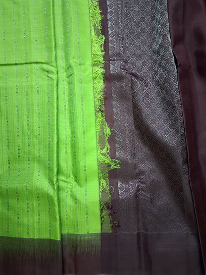 Korvai join where the parrot-green body meets the wine-aubergine border