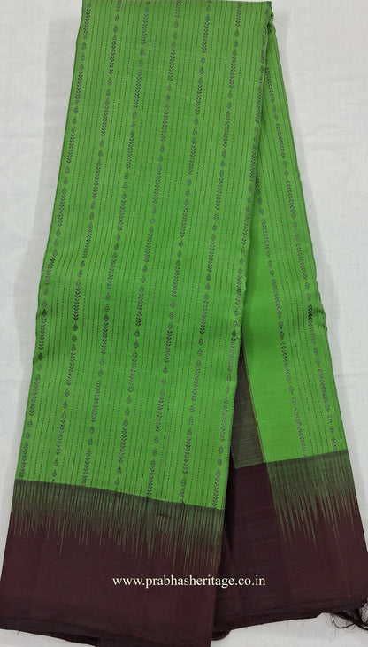 Full length of the saree long-folded, showing the parrot-green body and wine-aubergine pallu