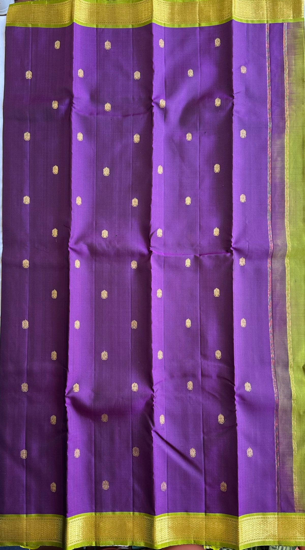 Gold zari buttas on the jamun purple silk body of the Kalyani Mahotsavam saree