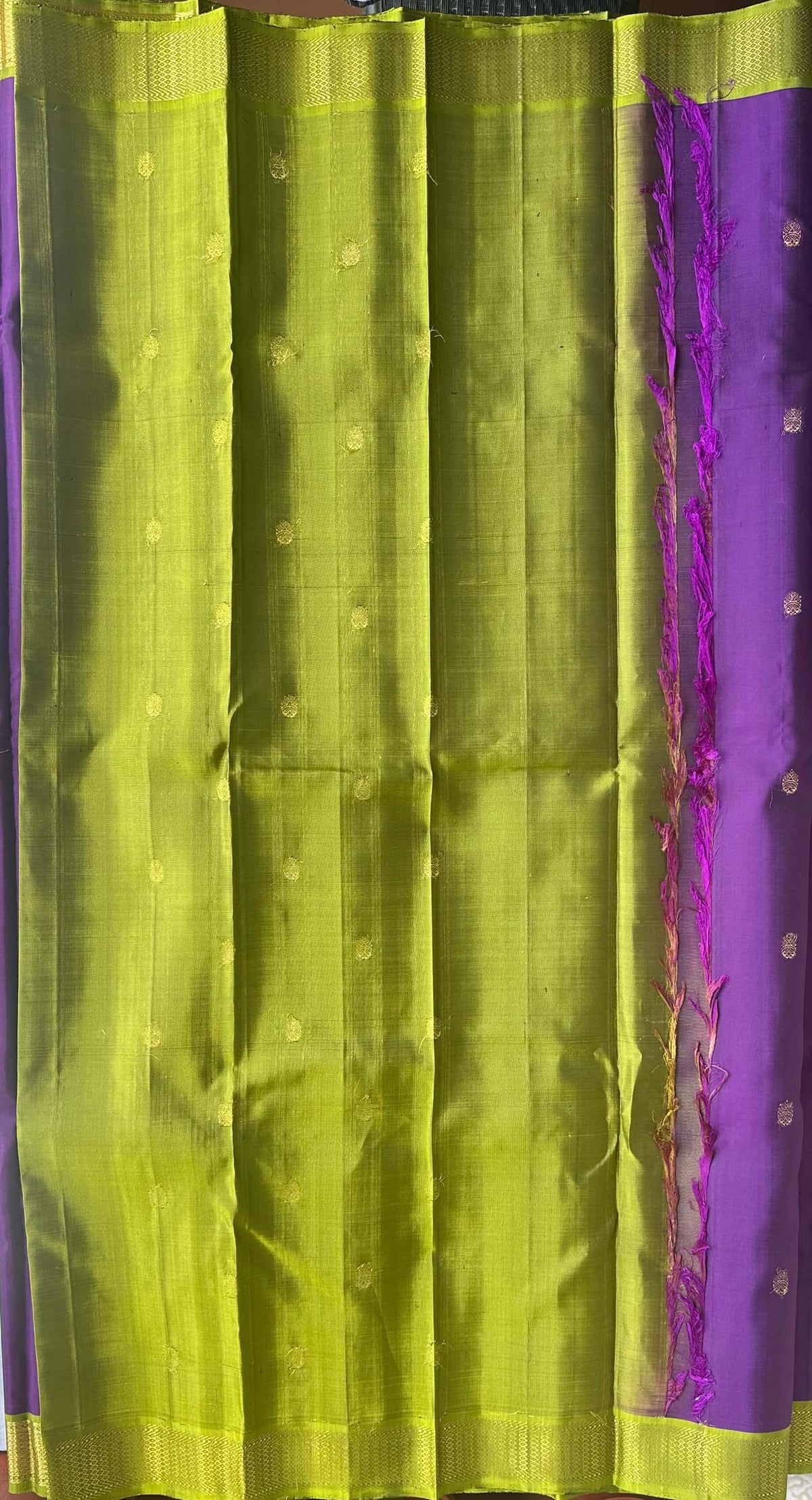 Korvai join where the jamun purple body meets the parrot-green zari border