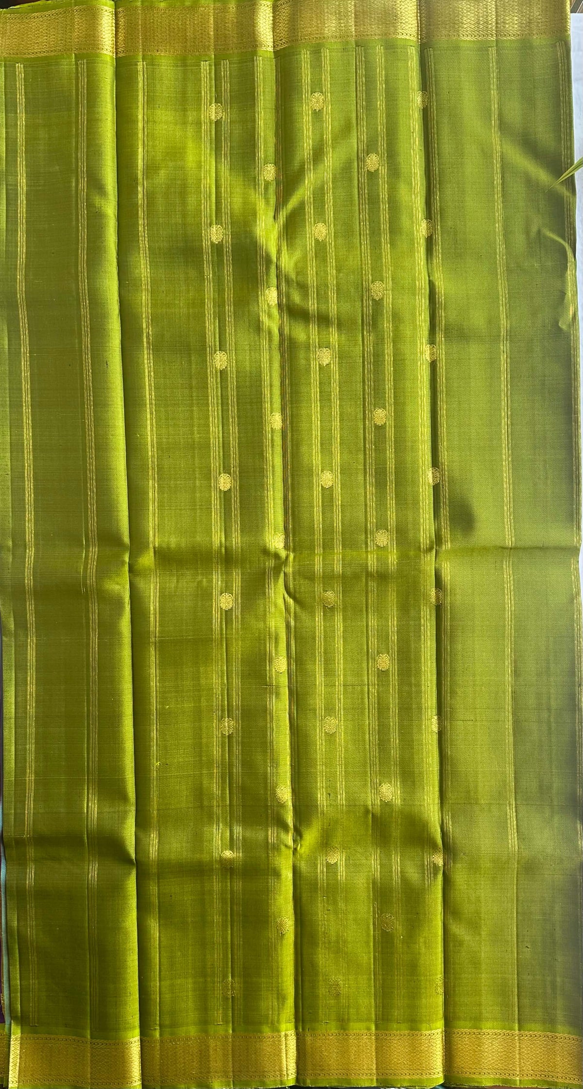 Parrot-green pallu worked in gold zari on a jamun purple Kanchipuram silk saree