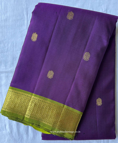 Jamun purple Kanchipuram silk saree folded to show the body and parrot-green border