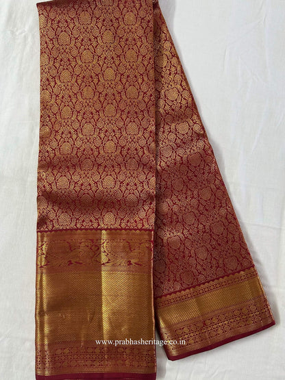Full length of the crimson-red Kanchipuram silk saree with its asymmetric zari border