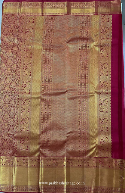 Pallu with peacock motifs and geometric zari panels on the crimson-red silk saree