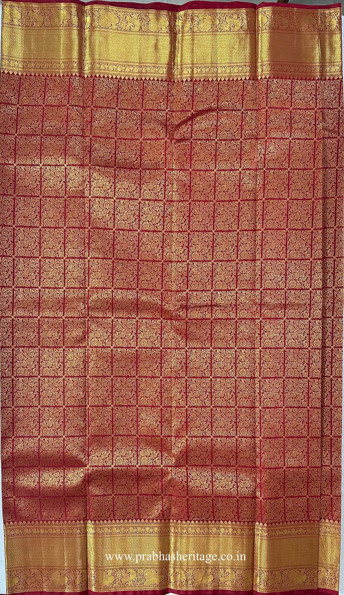 All-over gold zari floral grid on the red silk body of the saree