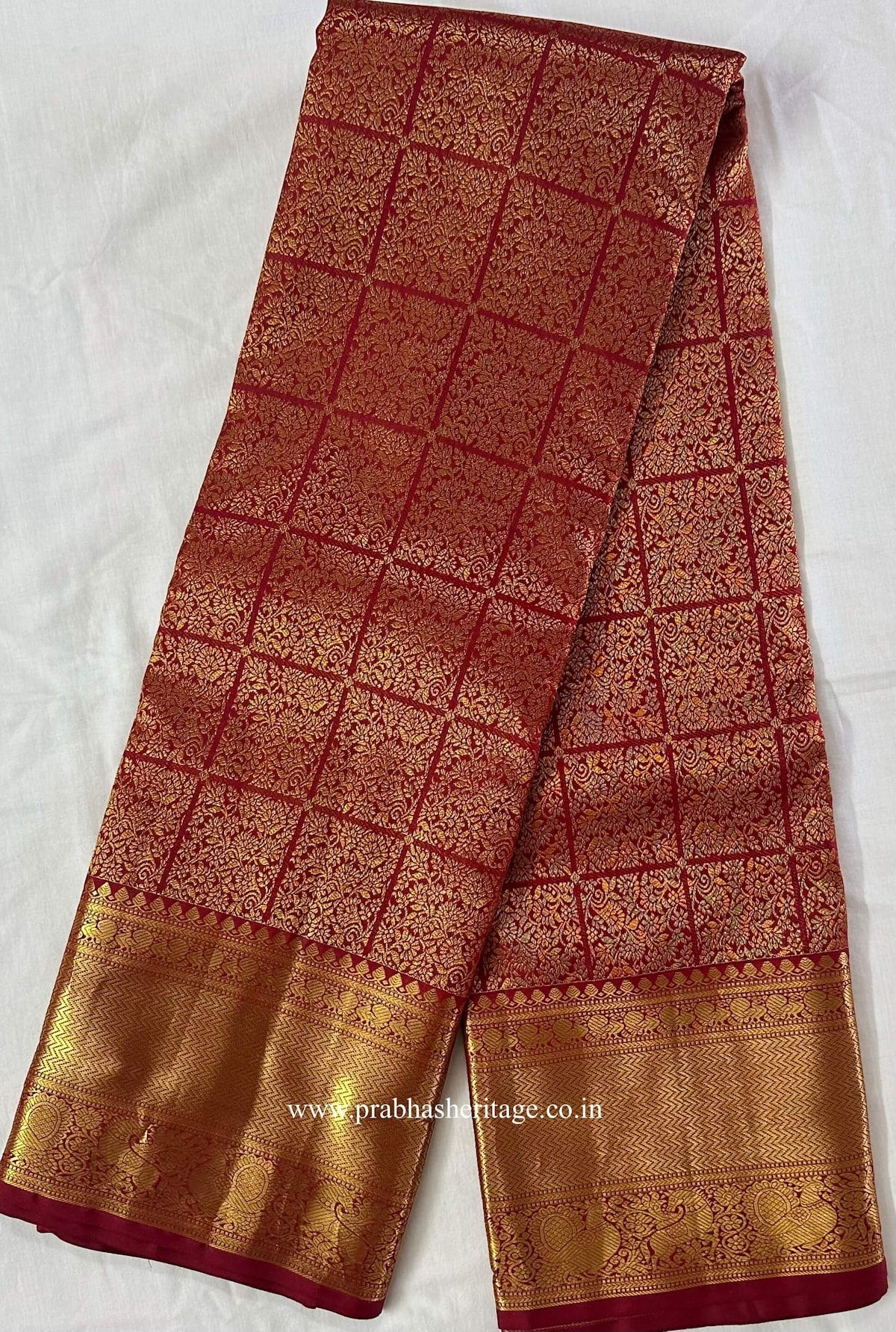Full length of the red Kanchipuram silk saree with its gold zari borders