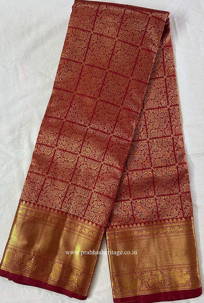 Full length of the red Kanchipuram silk saree with its gold zari borders