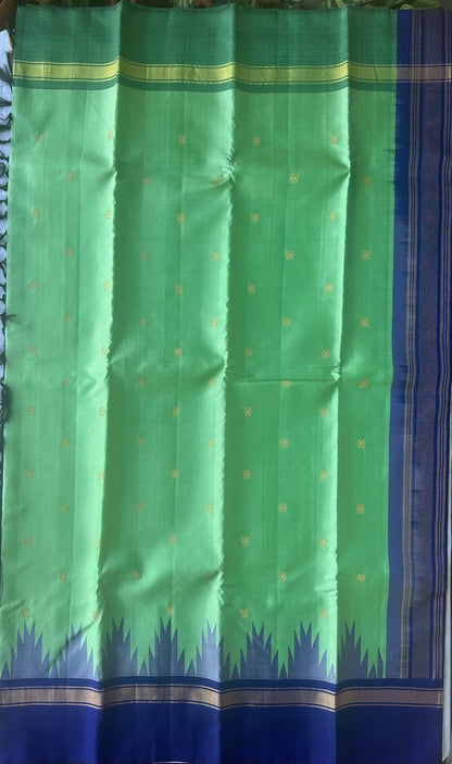 Gold zari buttas on the leaf green silk body of the Mangala Gopuram saree
