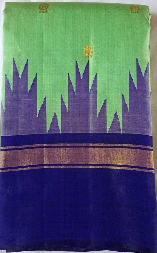 Leaf green Kanchipuram silk saree folded to show the body and royal blue border