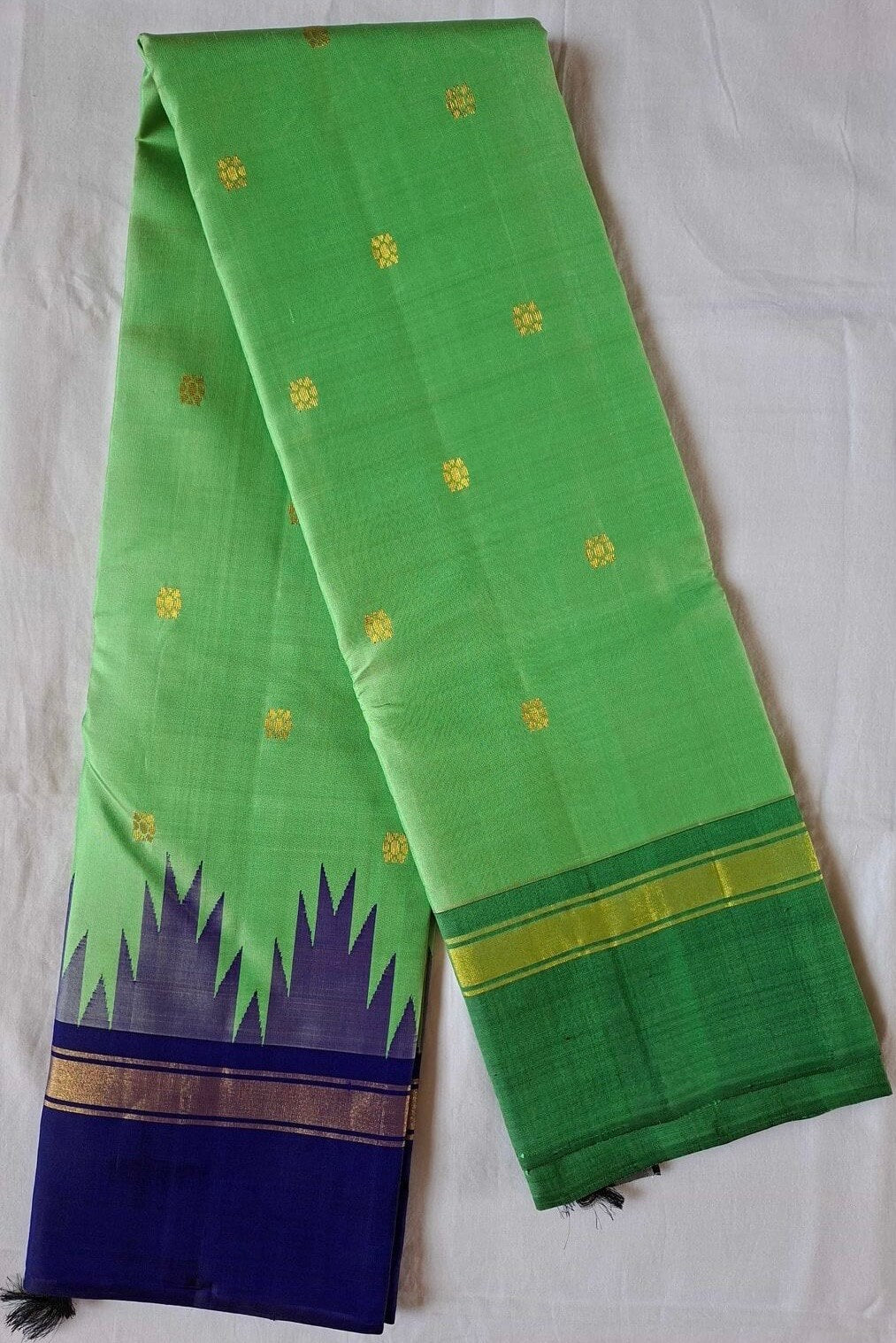 Full length of the leaf green Kanchipuram silk saree with its royal blue Korvai border