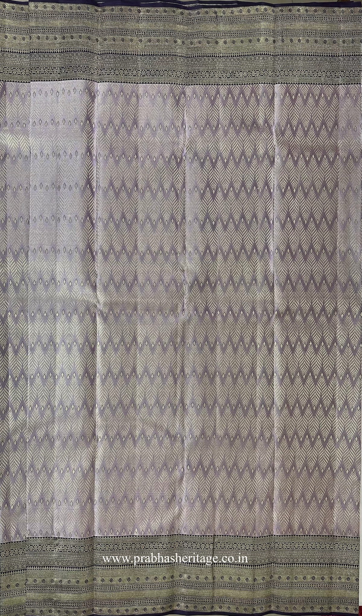 Chevron zari pattern on the silvery lavender silk body of the saree
