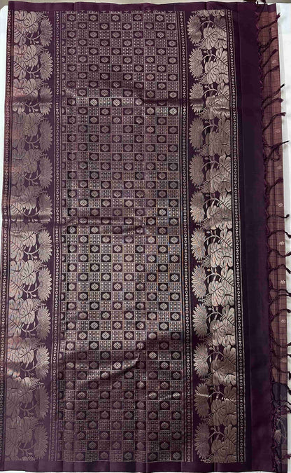 Deep aubergine-plum pallu with geometric patterning and broad floral bands on a pure soft silk saree