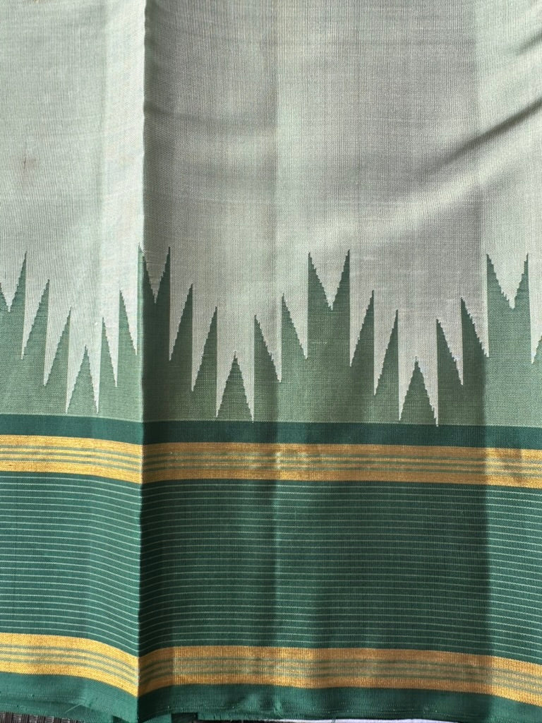 Korvai temple border where the ivory sage body meets the emerald green zari border