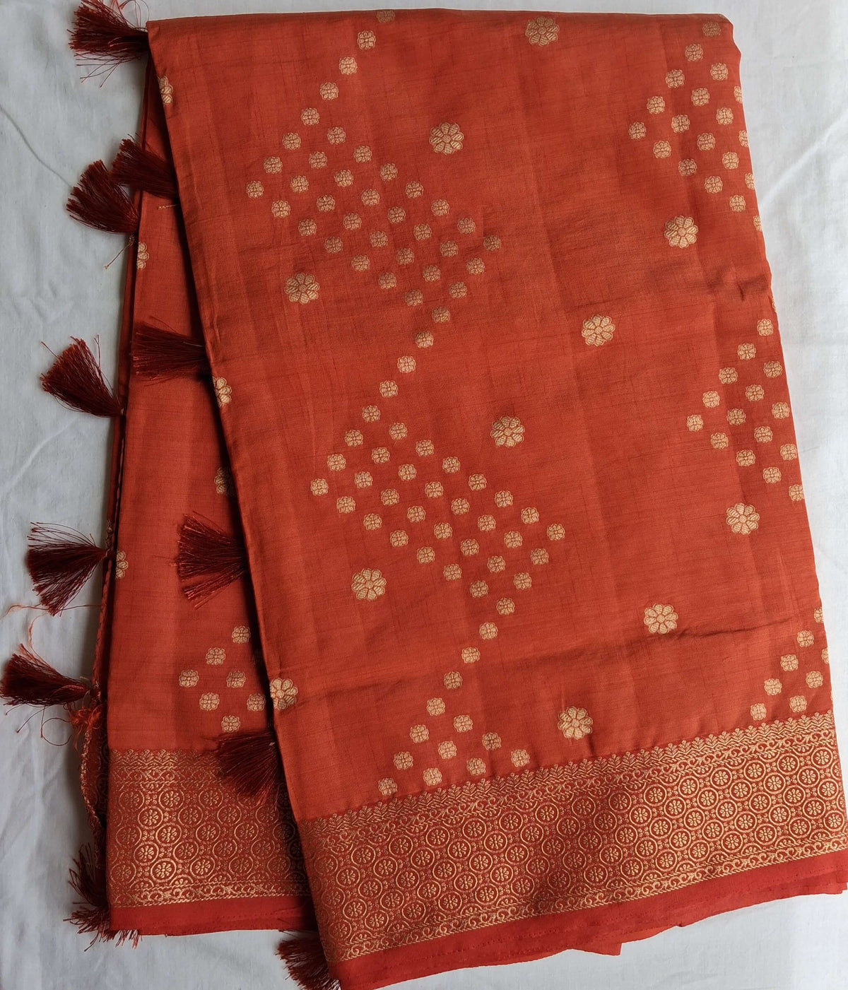 Long fold view of Sengal Varnam brick red semi-tussar saree showing buttas and border