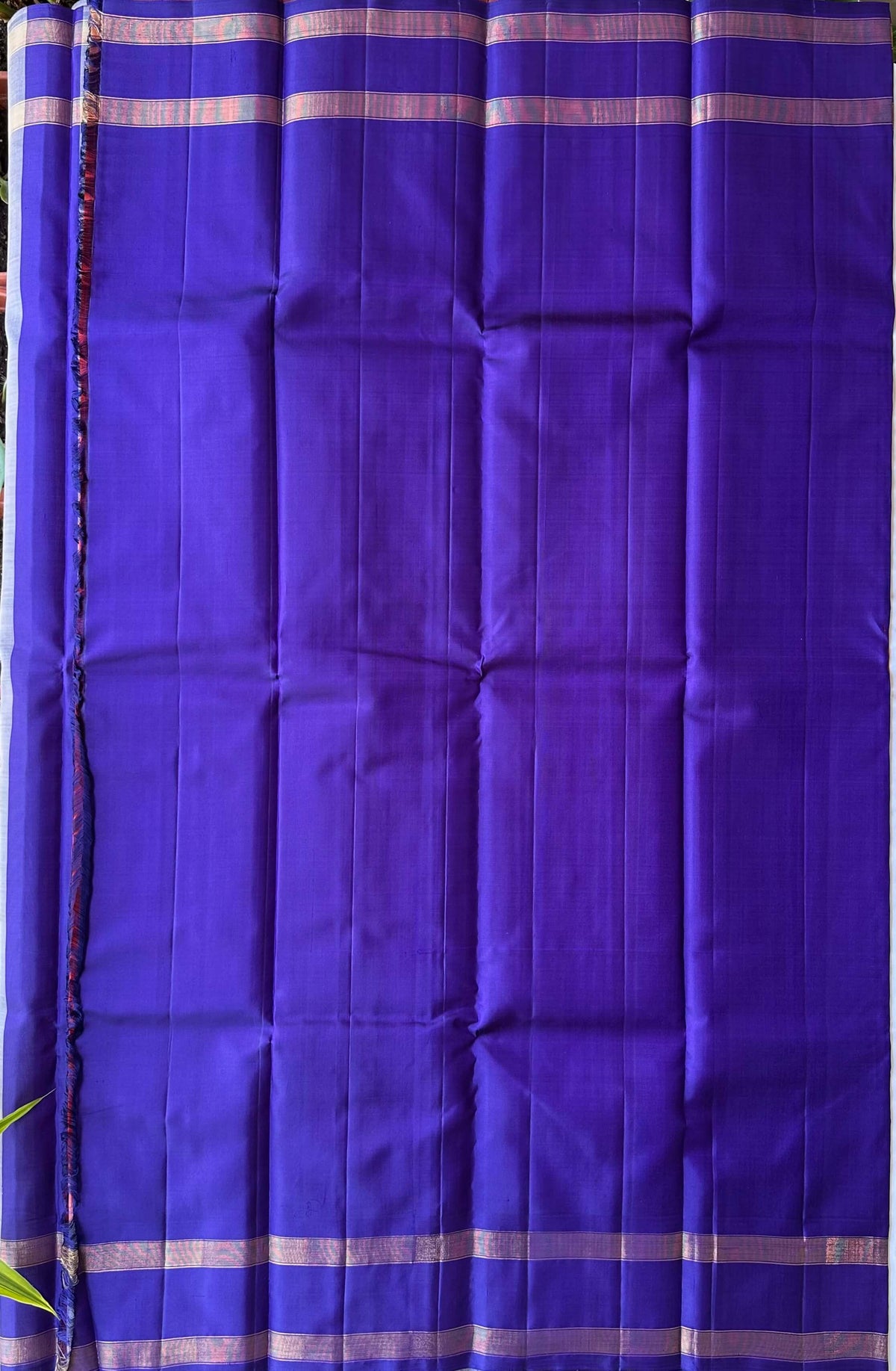 Attached deep-bluish violet contrast blouse piece with a gold zari border