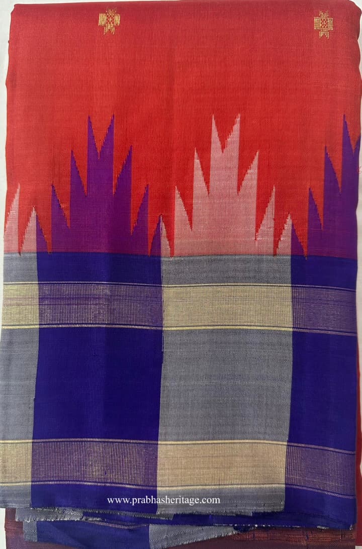 Vermilion-orange Kanchipuram silk saree folded to show the body and temple border