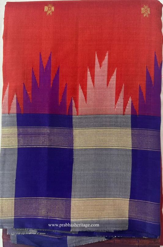Vermilion-orange Kanchipuram silk saree folded to show the body and temple border