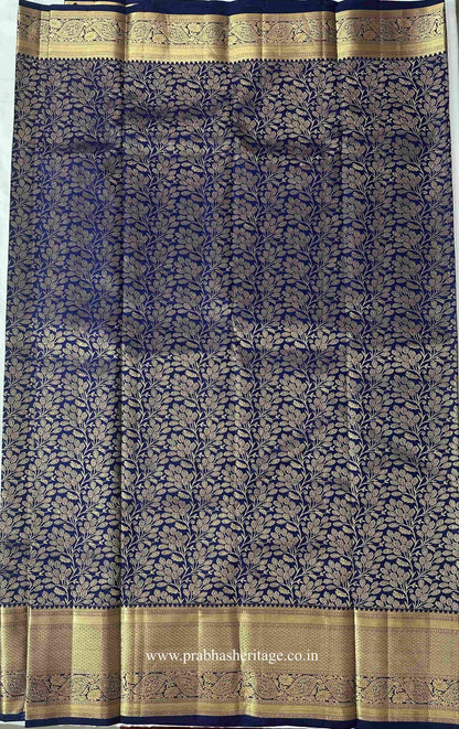 All-over gold zari botanical vine pattern on the navy-blue silk body of the saree