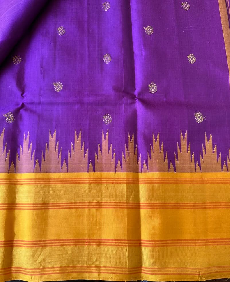 Korvai temple border where the violet body meets the mustard-gold zari border